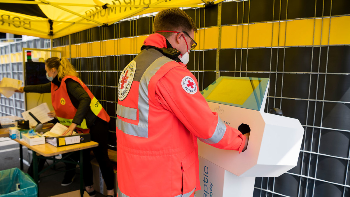A medical staffer sanitizes his hands before Dortmund vs. Schalke